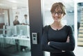 Shes got an open door policy. a young businesswoman standing with her arms crossed in an office doorway. Royalty Free Stock Photo