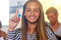 Shes got a question that needs answering. Portrait of an enthusiastic schoolgirl raising her hand to answer a question Royalty Free Stock Photo