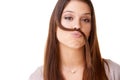 Shes got a quirky side. Studio shot of a beautiful young woman playfully creating a mustache from her own hair against a