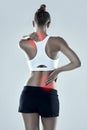 Shes got some problem areas. Studio shot of an athletic young woman holding her neck and back in pain against a grey