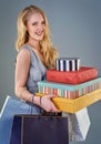 Shes a great contributor to economic health. Cropped studio shot of a happy young woman holding a selection of shopping Royalty Free Stock Photo