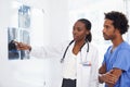 Shes great at explaining x-rays. a female African American doctor and male nurse studying x-rays.