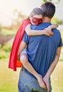 Shes had a hard day being a superhero. a little girl being comforted by her father outside.