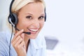 Shes just a call away. Closeup portrait of a beautiful woman smiling and wearing a headset.