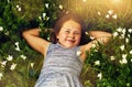 Shes a little nature lover. a cute little girl lying in a field of wildflowers outside.