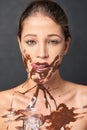 Shes a lover of chocolate. Studio shot of an attractive young woman being tempted by something sweet.