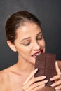 Shes a lover of chocolate. Studio shot of an attractive young woman being tempted by something sweet.