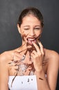 Shes a lover of chocolate. Studio shot of an attractive young woman being tempted by something sweet.