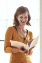 Shes loving the direction of this design brief. an attractive young woman looking over some paperwork in a modern office Royalty Free Stock Photo