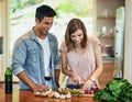 Shes making something healthy tonight. a young man watching his wife prepare dinner.