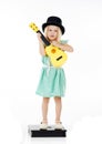 Shes a mini musician. Studio shot of a cute little girl playing with her toy guitar against a white background. Royalty Free Stock Photo
