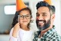 Shes my clever little cutie. Portrait of a cute little girl and her father playing with dress-up props at home. Royalty Free Stock Photo