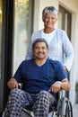 Shes my rock. Portrait of a senior woman pushing her husband in a wheelchair outdoors. Royalty Free Stock Photo