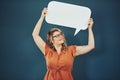 Shes never afraid to speak out. Studio shot of a woman holding a speech bubble against a blue background.