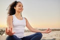 Shes on the path to inner peace. an attractive young woman meditating on the beach. Royalty Free Stock Photo