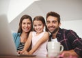 Shes ready for a lesson in wireless technology. Portrait of a happy married couple and their young daughter using a Royalty Free Stock Photo