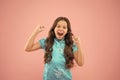 Shes a real winner. Little girl shout and make winner gesture on pink background. Happy small winner active gesturing in