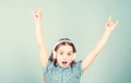 Shes a rock star. Little kid showing horn hand gesture like a hard rock or heavy metal fan. Cute small child listening Royalty Free Stock Photo