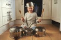 Shes a rock star in the making. a little girl playing drums on a set of pots in the kitchen. Royalty Free Stock Photo