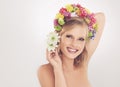 Shes a spring goddess. A young woman with a flower arrangement in her hair smiling at the camera.