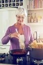 Shes still the best cook in the family. a senior woman cooking in her kitchen.