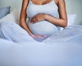 Shes about to fall in love in a big way. a pregnant young woman relaxing on the bed at home. Royalty Free Stock Photo