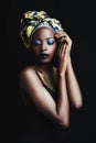 Shes a true african beauty. A beautiful african woman posing against a black background.