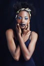 Shes a true african beauty. A beautiful african woman posing against a black background.