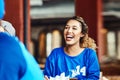 Shes a true blue fan. a woman watching a sports game with friends at a bar.