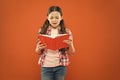 Shes a true bookworm. Adorable small child reading book on orange background. Cute little girl reading for fun