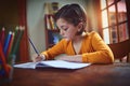 Shes very diligent when it comes to doing her homework. a little girl doing homework inside.