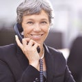 Shes very friendly on the phone. a mature businesswoman talking on the phone.