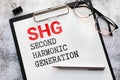 SHG - Second Harmonic Generation acronym text on notepad, abbreviation concept background Royalty Free Stock Photo