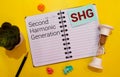 SHG - Second Harmonic Generation acronym text on notepad, abbreviation concept background Royalty Free Stock Photo