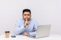 Shh, be quiet! Businessman sitting office workplace with laptop on desk, asking for silence or secrecy