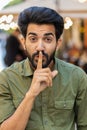 Indian man presses finger to lips makes silence hush sign do not tells gossip secret quiet in city Royalty Free Stock Photo