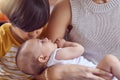 Shh, big brother is here. an adorable little boy kissing his baby brother while his mother cradles him at home. Royalty Free Stock Photo