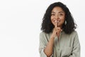 Shh can you keep secrets. Portrait of charming friendly-looking delighted cute dark-skinned woman with curly hairstyle Royalty Free Stock Photo