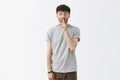 Shh I make surprise. Portrait of excited emotive attrative young man in casual outfit making shush gesture with index