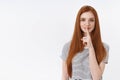 Shh secrets must save. Charming attractive self-assured redhead girl straight ginger hair show index finger lips seal