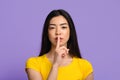 Shhh. Mysterious young asian lady showing keep silence sign at camera Royalty Free Stock Photo