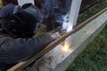 Shielded metal arc welding. Worker welding metal with electrodes, wearing protective helmet and gloves. Close up of electrode Royalty Free Stock Photo