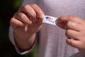 American woman picks up I oval red white and blue I voted sticker after leaving polling place and holds Royalty Free Stock Photo