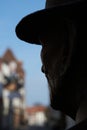 Shilouette of the head of a sculpture against a blurred background with the view of buildings of a city