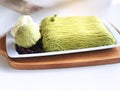 Shiltarae Bingsu matcha green tea with green tea ice cream whipped topping and red bean caramel, put on white plate and wooden. Royalty Free Stock Photo