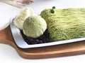 Shiltarae Bingsu matcha green tea with green tea ice cream whipped topping and red bean caramel, put on white plate and wooden. Royalty Free Stock Photo