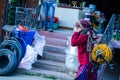 Indian Women walking on street.lifting heavy electric cable roll on her head