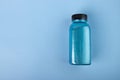 Shimmering bath salt in bottle, shiny blue cosmetics, bright cosmic sparkles, copy space