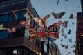 Shimmering Carnaby sign surrounded by butterflies on Carnaby Street, London, UK.