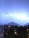 Shine and thunderstorm above mountain and city